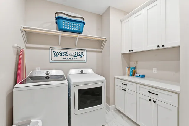 a utility room with dryer washer and sink