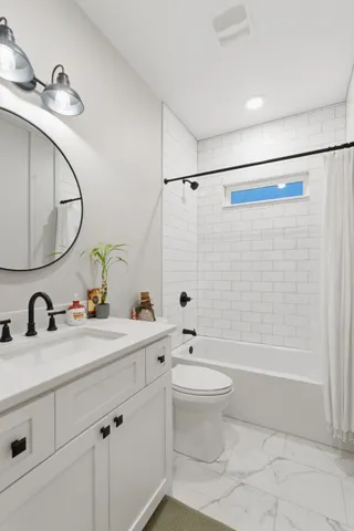 a bathroom with a double vanity sink toilet mirror and shower
