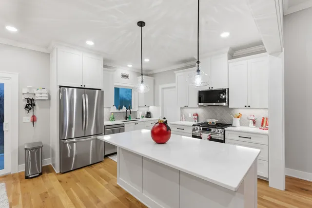 a kitchen with stainless steel appliances a refrigerator sink and wooden floor