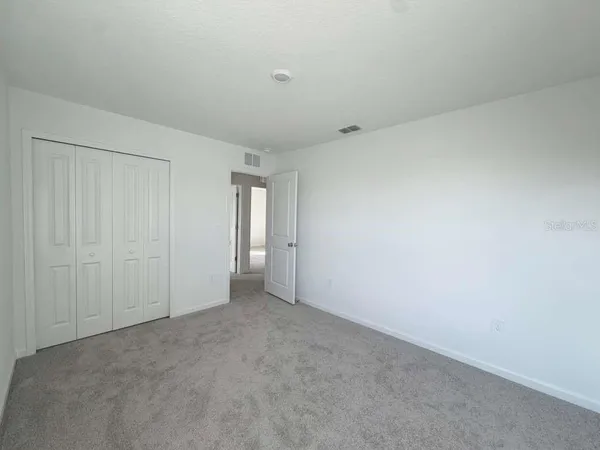 a view of an empty room and closet area