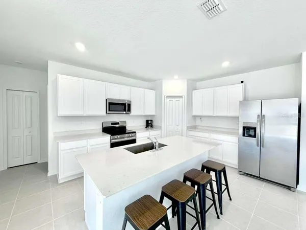 a kitchen with white cabinets and stainless steel appliances