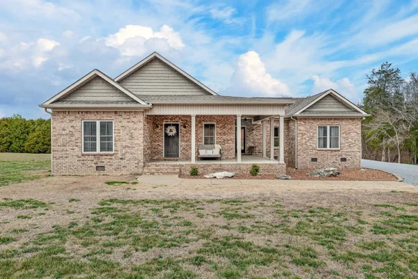 a front view of a house with a yard outdoor seating and garage