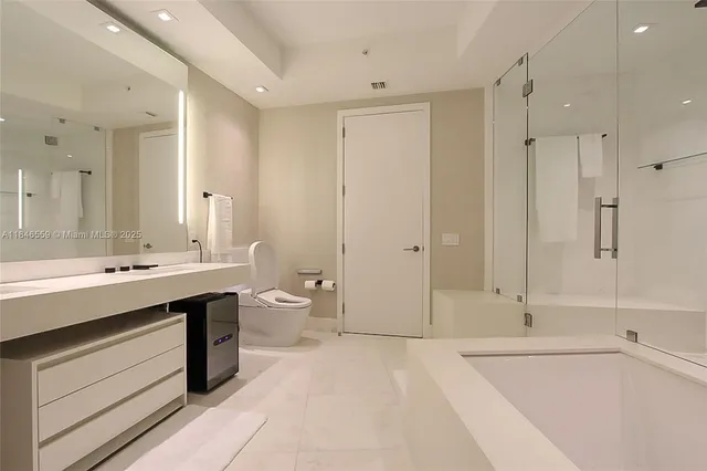 a bathroom with a granite countertop sink mirror vanity and toilet