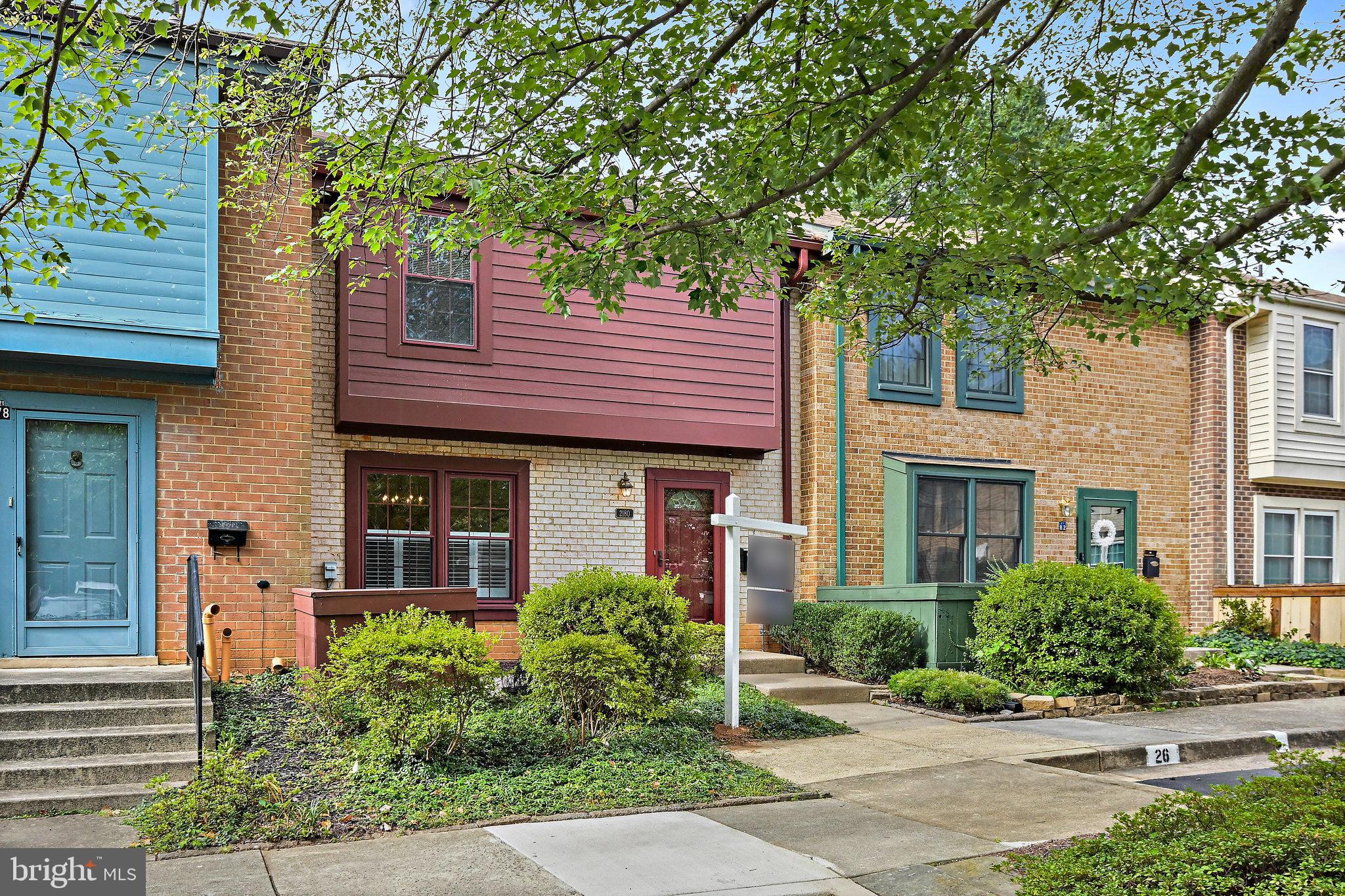 a front view of a house with plants and trees