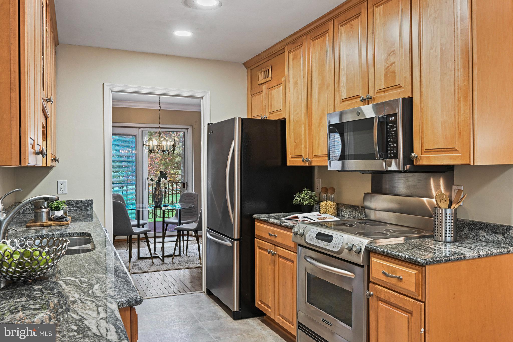 2180 Golf Course Drive Reston, VA 20191 - Photo 15 of 40 a kitchen with stainless steel appliances granite countertop a stove a refrigerator and a microwave