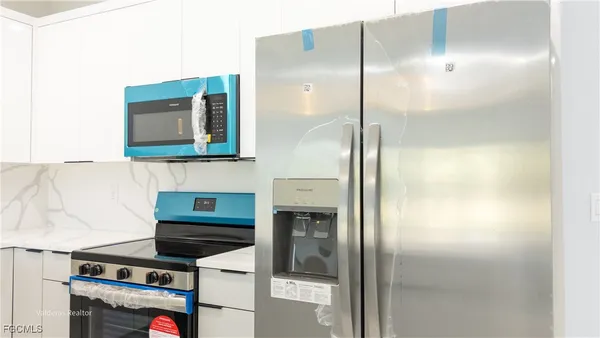 a kitchen with a refrigerator and a stove top oven