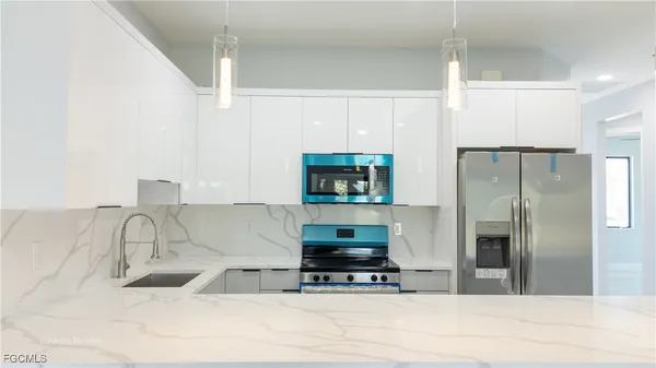 a kitchen with stainless steel appliances a stove a sink and a refrigerator