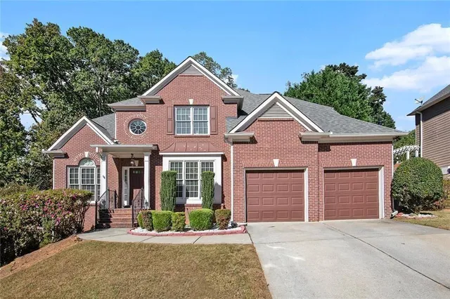 a front view of a house with a yard and potted plants