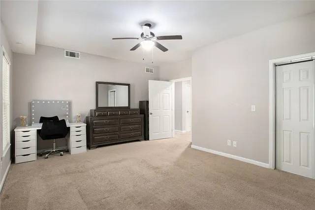 an empty room with windows and fan