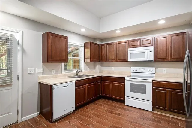 a kitchen with stainless steel appliances granite countertop a refrigerator and a stove top oven
