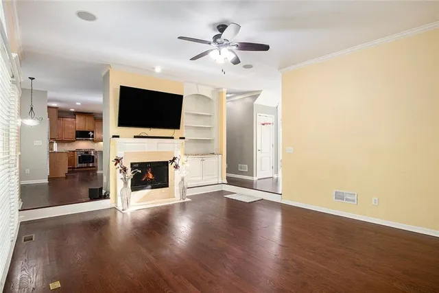 a view of a livingroom with a fireplace a flat screen tv and wooden floor