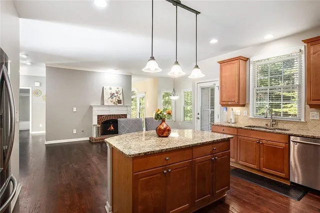 a kitchen with a sink stove and wooden floor