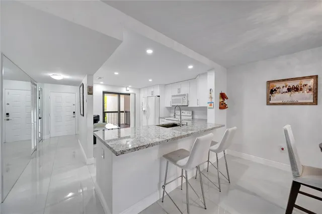 a kitchen with granite countertop a sink stove and refrigerator
