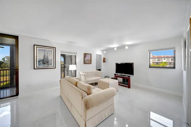a view of a hallway with wooden floor and a kitchen