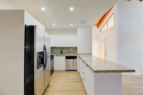 a kitchen with a refrigerator and a sink