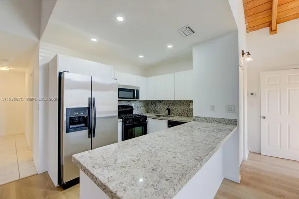 a kitchen with stainless steel appliances granite countertop a refrigerator and a sink