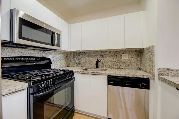 a kitchen with stainless steel appliances granite countertop a stove and a microwave