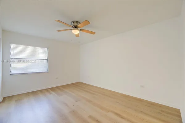 a view of a room with wooden floor and a ceiling fan
