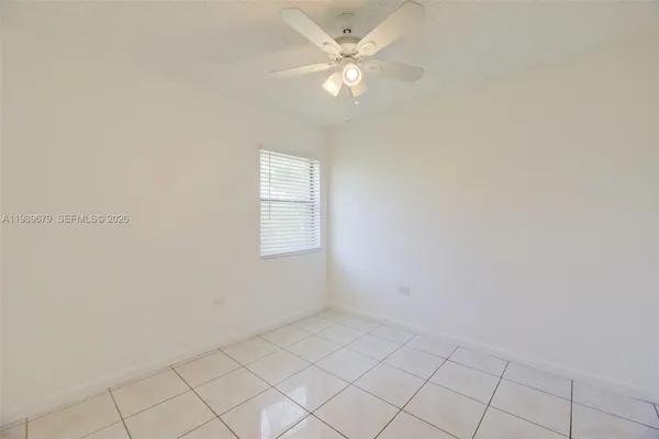 an empty room with white cabinet and a ceiling fan