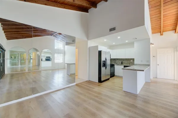 a view of a kitchen with a sink and a refrigerator