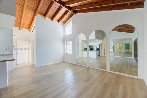a view of empty room with wooden floor