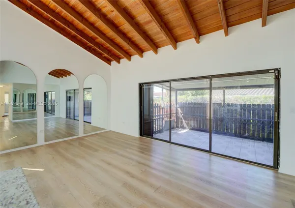 a view of empty room with wooden floor