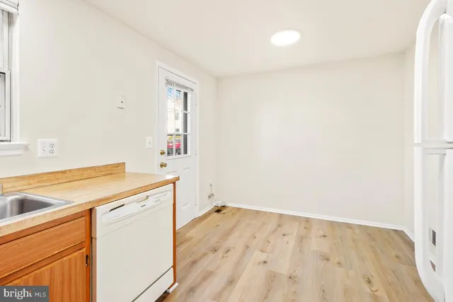 a utility room with wooden floor washer and dryer