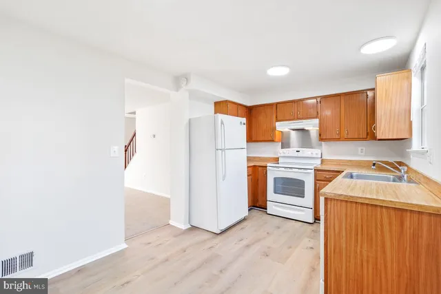 a kitchen with stainless steel appliances a refrigerator and a stove top oven