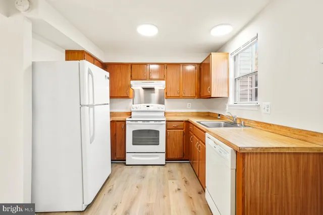 a kitchen with granite countertop a white refrigerator and a stove