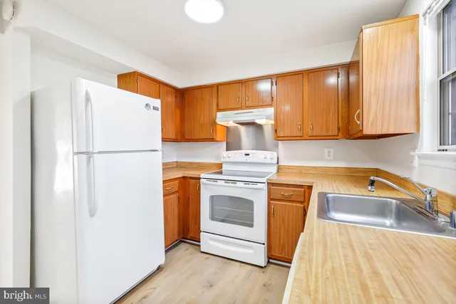 a kitchen with a refrigerator sink and cabinets