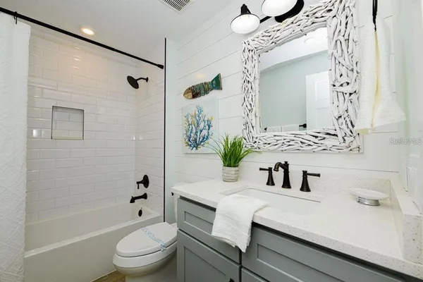 a bathroom with a sink a toilet a mirror and shower