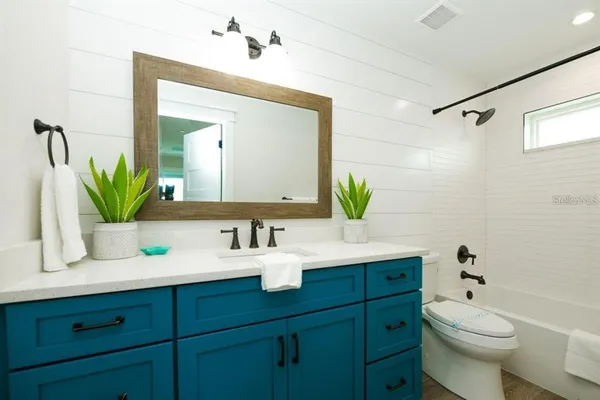 a bathroom with a granite countertop toilet sink and a mirror