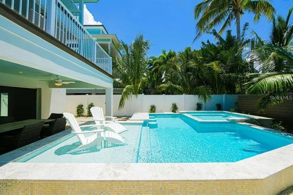 a view of backyard with swimming pool and furniture