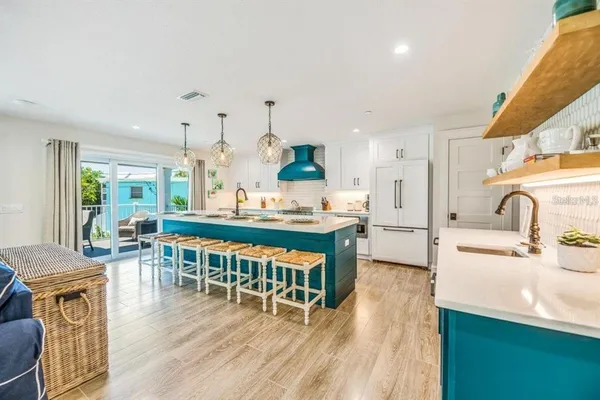a kitchen with stainless steel appliances granite countertop a table chairs stove a sink and dishwasher