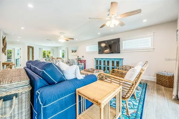 a living room with furniture a flat screen tv and a dining table
