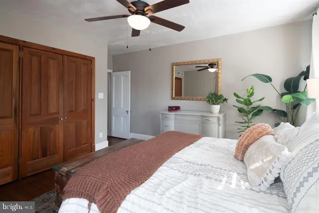 a bedroom with a bed potted plant with the wooden floor