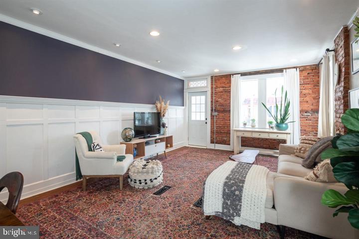 229 Benezet Street Philadelphia, PA 19118 - Photo 4 of 31 a living room with furniture a flat screen tv and a large window