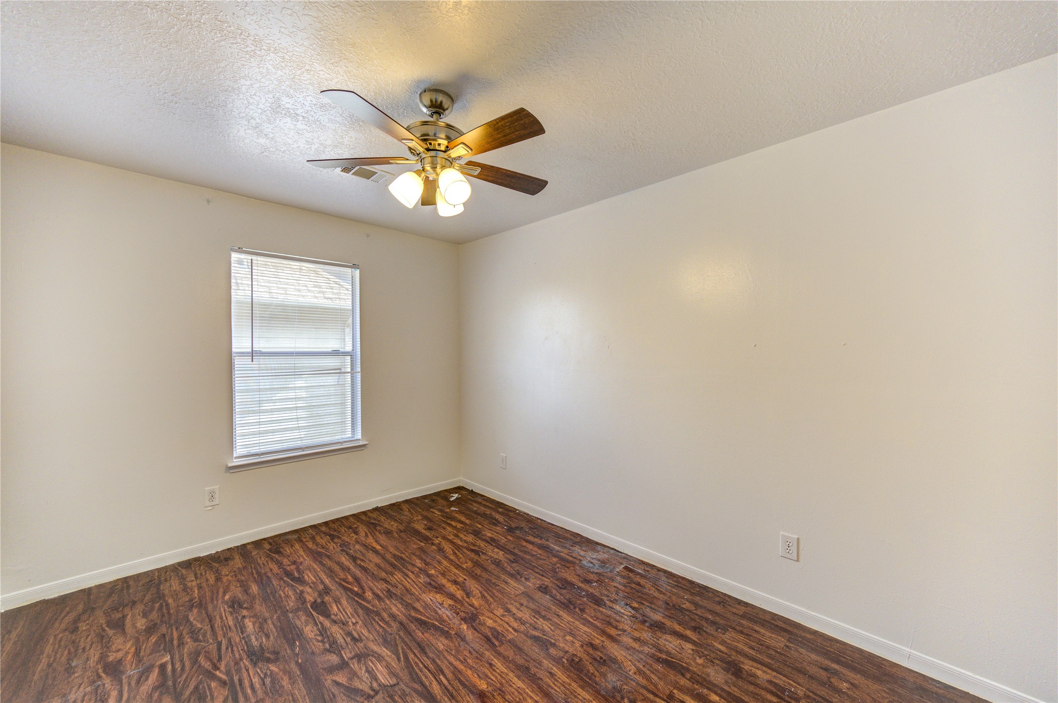 10338 Timberloch Drive Houston, TX 77070 - Photo 17 of 22 a view of an empty room with chandelier fan and wooden floor