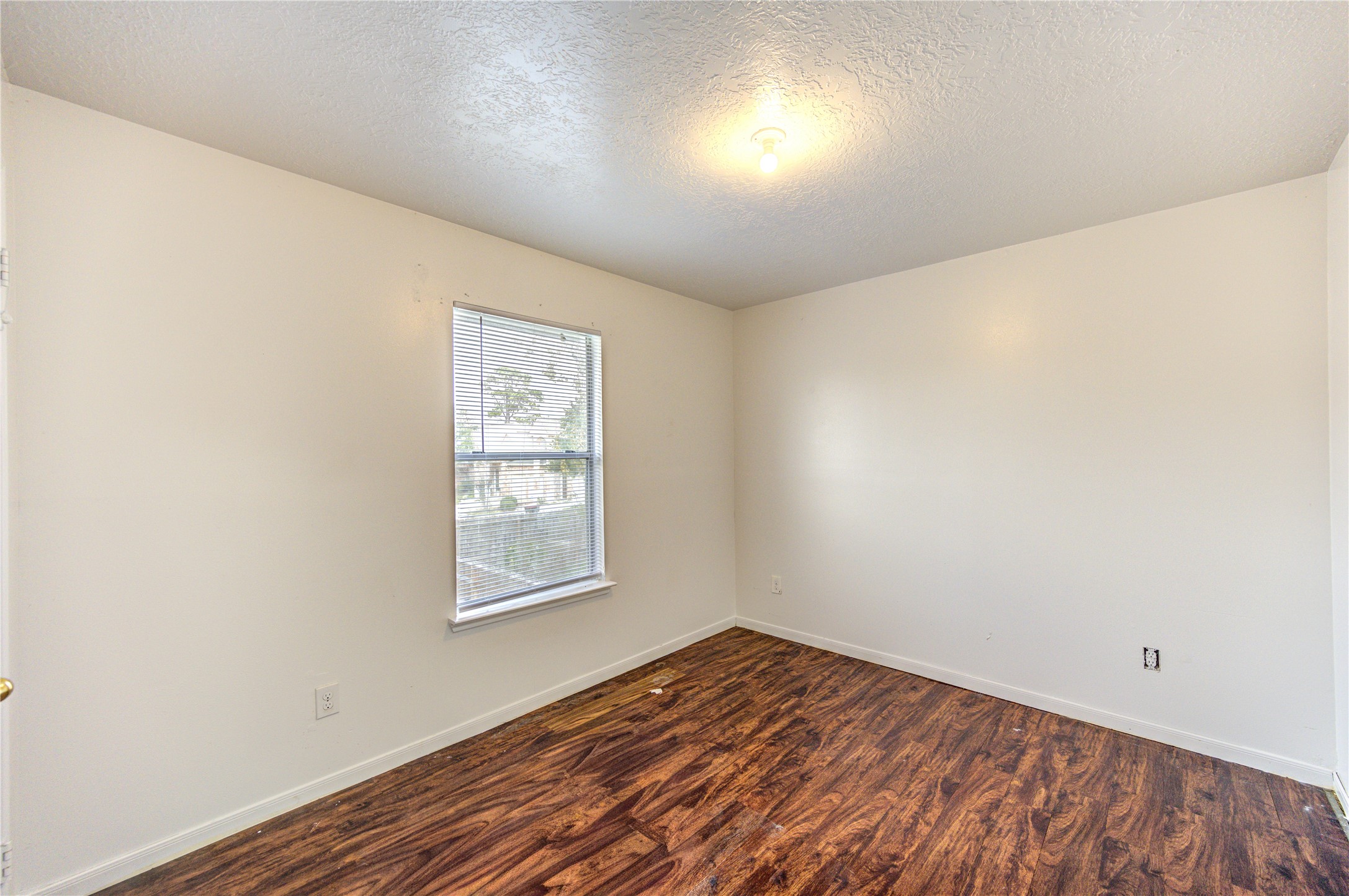10338 Timberloch Drive Houston, TX 77070 - Photo 18 of 22 an empty room with wooden floor and windows