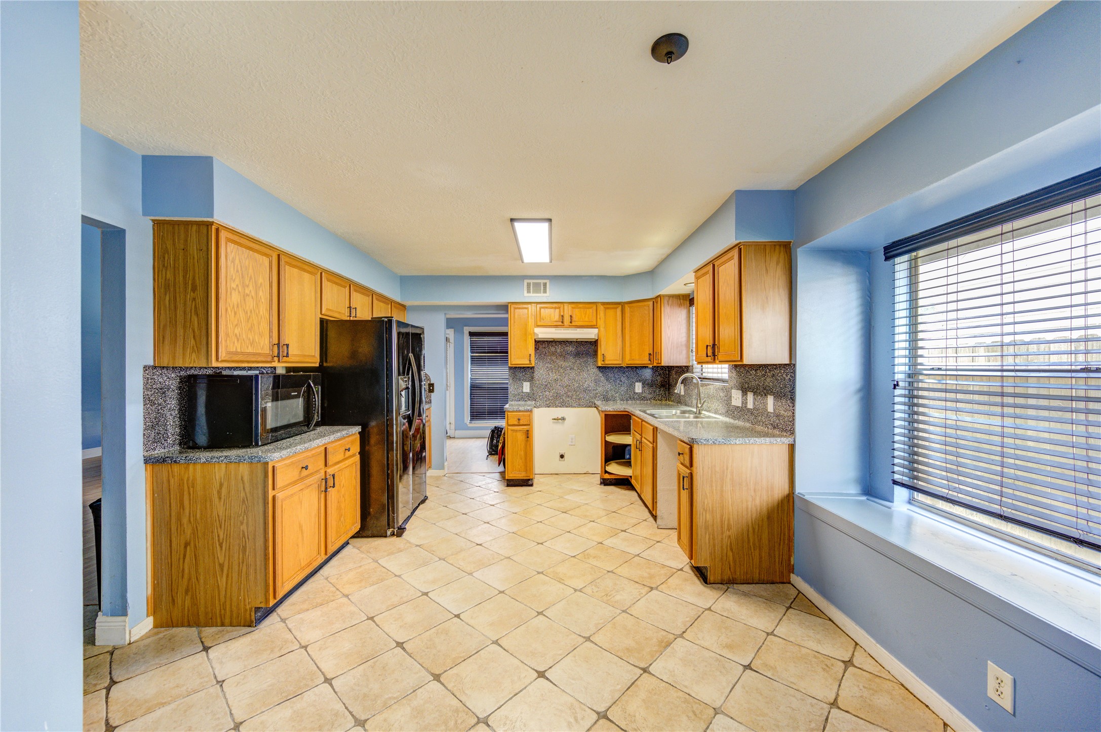 10338 Timberloch Drive Houston, TX 77070 - Photo 9 of 22 a large kitchen with stainless steel appliances a stove a sink and a refrigerator