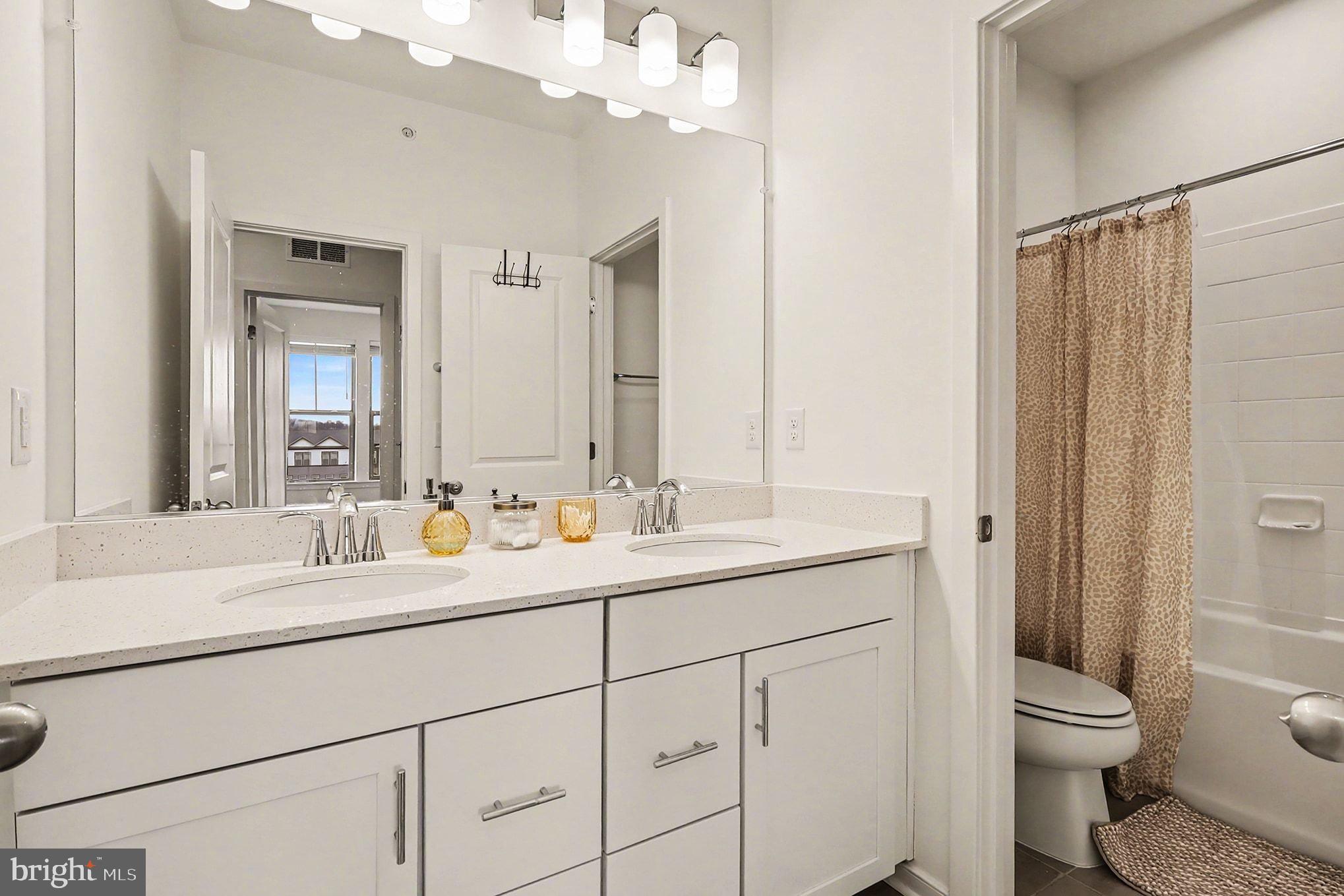 45956 Swallow Terrace Sterling, VA 20165 - Photo 19 of 29 a bathroom with a toilet a sink a mirror a vanity and shower