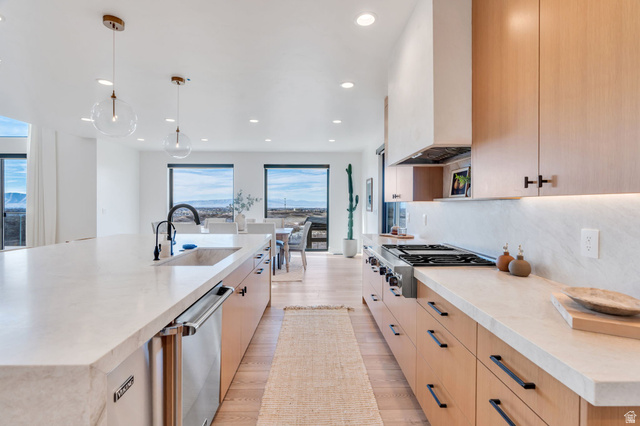 3918 South Mapleton Ests Drive Mapleton, UT 84664 - Photo 22 of 103 Kitchen featuring light stone countertops, tasteful backsplash, stainless steel appliances, light wood-style floors, and hanging light fixtures