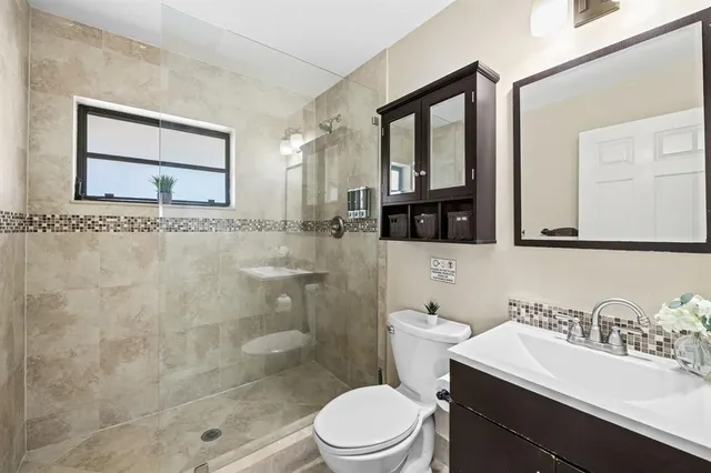 a bathroom with a sink a toilet and shower