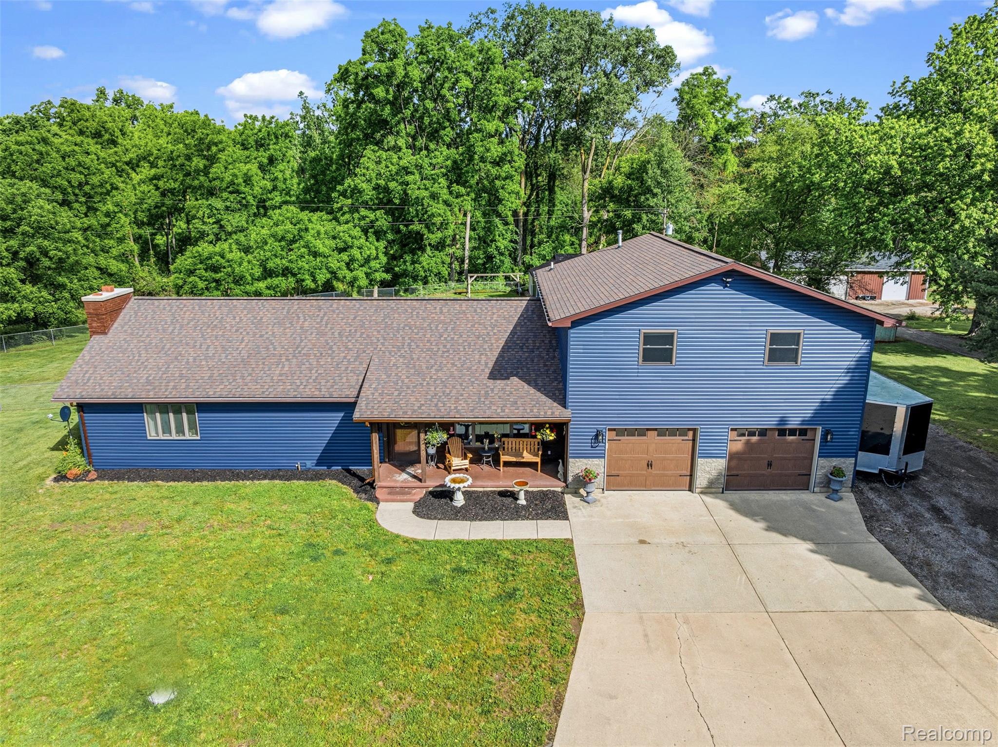 6699 Lansing Road Durand, MI 48429 - Photo 3 of 53 Blue siding exterior with a brown shingle roof and a covered front porch