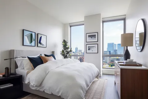 a bedroom with a bed and a lamp with dresser