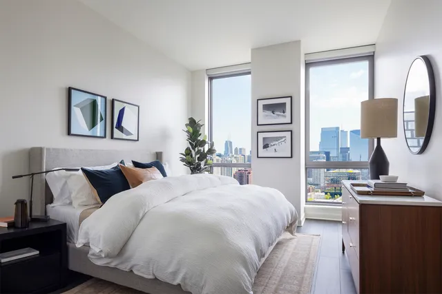 a bedroom with a bed and a lamp with dresser