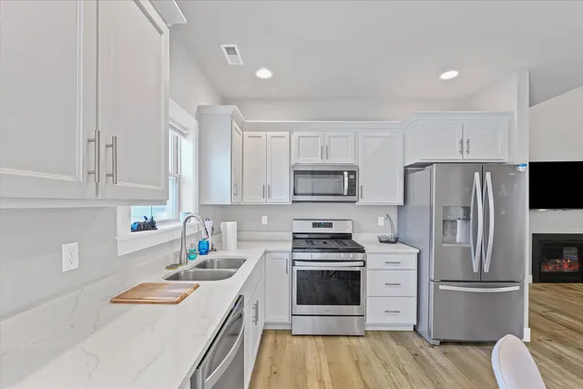 a kitchen with stainless steel appliances a refrigerator stove and white cabinets