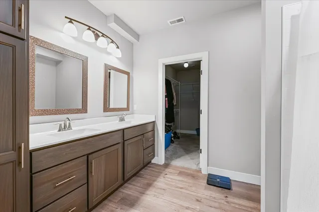 a en suite bathroom with a double vanity sink and a mirror