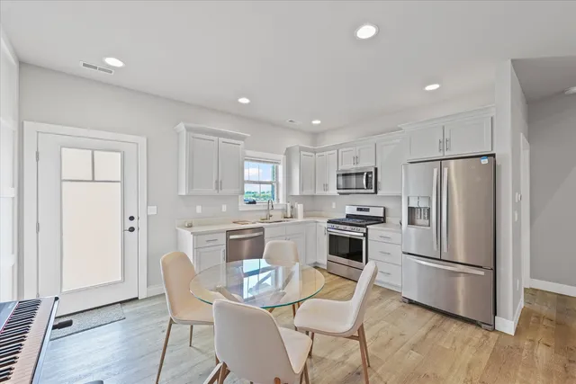 a kitchen with white cabinets and stainless steel appliances