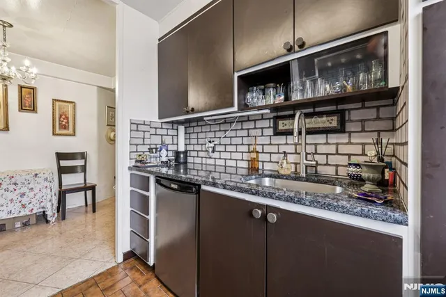a kitchen with kitchen island granite countertop a stove a sink and a microwave